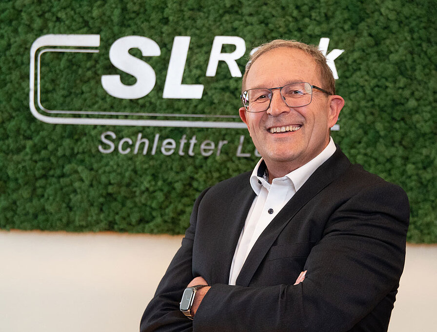 [Translate to English:] Portrait Georg Bauer vor Mooswand mit SL Rack Logo