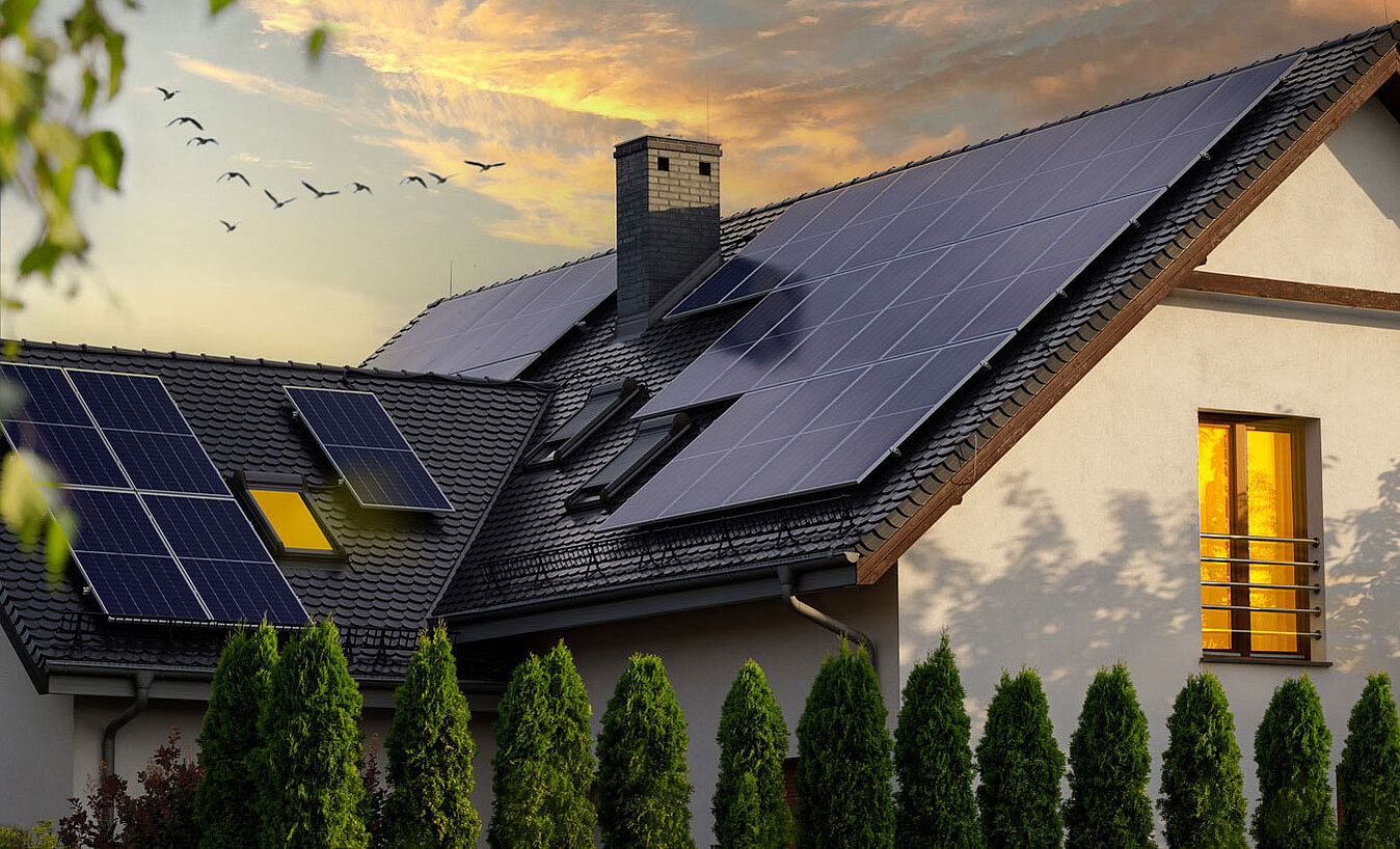 [Translate to English:] Haus mit Photovoltaik-Anlage auf Dach im Abendrot